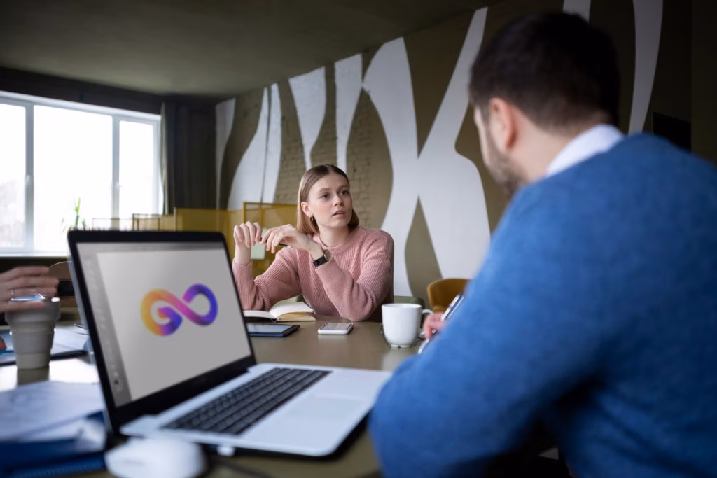Designer presenting a logo concept on a laptop to a colleague